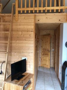 ベルガーエンデ・レートヴィッシュにあるOstseebungalow-Petersの木製の壁に薄型テレビが備わる広い木造の客室です。