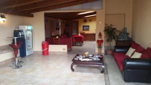 a living room with a red couch and a table at Barbara B&B in Fontane Bianche