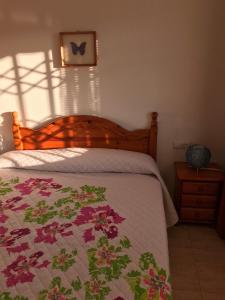 Un dormitorio con una cama con un edredón de flores. en Cala Azul 304-306 Tamarit, en Tamarit
