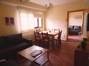 a living room with a table and chairs and a couch at Casa Rural Grajos I in Grajos