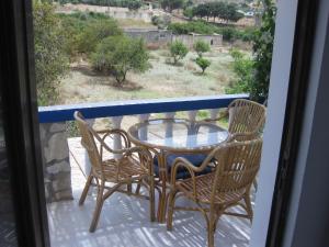 a table and chairs on a balcony with a view at Kalypso Apartments in Leipsoi