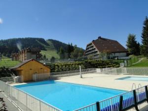 une grande piscine bleue en face d'un bâtiment dans l'établissement appartement, à Métabief