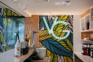 a kitchen with a colorful wall with a sign on it at Vanilla Garden Boutique Hotel - Adults Only in Playa de las Americas