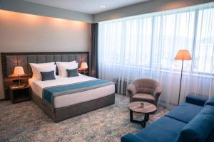 una camera d'albergo con letto e divano di Radon Plaza a Sarajevo