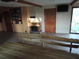a wooden bench in a room with a fireplace at Ptasi Folwark in Dolistowo