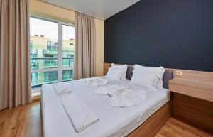 ポモリエにあるApartments in Atlanticのベッドルーム1室(白いシーツ付きのベッド1台、窓付)