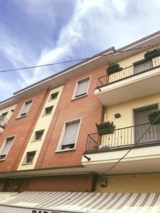 Savignano sul PanaroにあるHotel Cinziaの窓とバルコニー付きの高いレンガ造りの建物