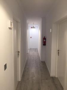 an empty hallway with white walls and wooden floors at Las Américas - Mares in Torre del Mar +29 photos