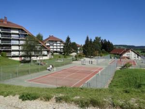 a tennis court with two people on it at appartement in Métabief