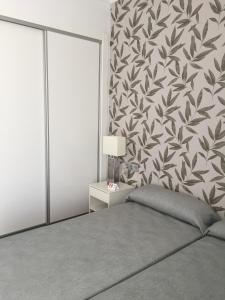 a bedroom with a bed and a floral wall at Las Américas - Mares in Torre del Mar