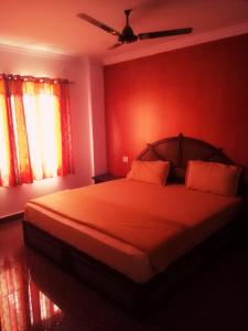 a bedroom with a bed with red walls and a ceiling at Rexon Residency in Kattappana