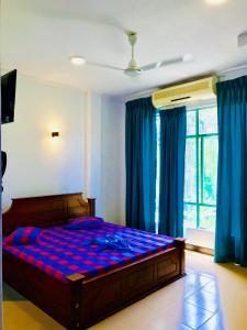 1 dormitorio con 1 cama grande y edredón azul en Travellers Halt, en Ratnapura