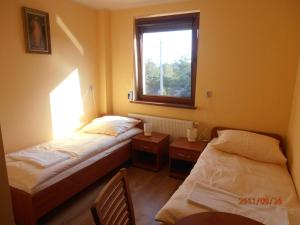 - 2 lits dans une petite chambre avec fenêtre dans l'établissement Ave Łagiewniki, à Cracovie