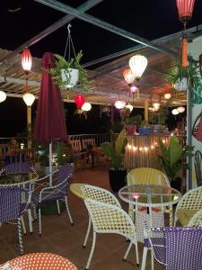 um restaurante com mesas, cadeiras e luzes em Thuong Hai Hotel em Phong Nha