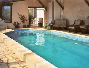 ein Pool mit blauem Wasser in einem Haus in der Unterkunft Château Ardilleux in Ardilleux