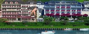 two people in a boat in the water near a building at Moselstern Hotel Brixiade &Triton in Cochem