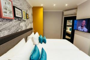 1 dormitorio con 1 cama grande con almohadas azules en Oliver Plaza Hotel en Londres