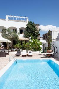 Irgoli的住宿－Gulf of Orosei Luxury Mediterranean House，一座带椅子的大型游泳池和一座建筑