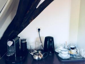 a table with a coffee maker and cups on it at B&B Het Rode Hert in Doesburg