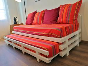 a couch with a striped blanket on top of it at La Loge du Theatre - Saintes in Saintes