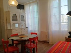 a dining room with a table and red chairs at La Loge du Theatre - Saintes in Saintes