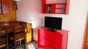 a red dresser with a television on top of it at appartement in Métabief