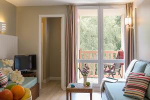 - un salon avec un canapé et une grande fenêtre dans l'établissement Résidence Pierre & Vacances Les Jardins de la Côte d'Opale, à Le Touquet-Paris-Plage