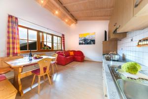 cocina y sala de estar con mesa y sofá en Pardellerhof Ferienhaus en Luson