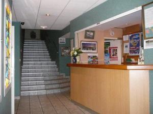a lobby with a staircase and a counter and stairs at Les Voyageurs in Sizun
