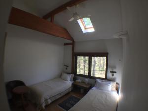 a bedroom with two beds and a skylight at Woody Hotel & Restaurant YUMEKOUBOU in Tsurui