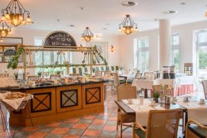 a restaurant with tables and chairs and a mirror at Best Western Wein- und Parkhotel in Nierstein