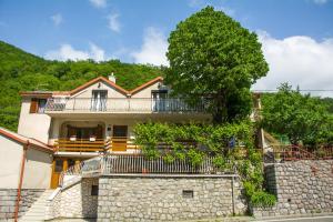 una casa con una pared de piedra y un árbol en Apartment Marina, en Senj