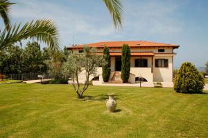 una casa con un jarrón en medio de un patio en Agriturismo San Gregorio, en San Vincenzo