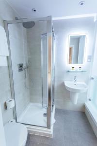 a bathroom with a shower and a toilet and a sink at Oliver Plaza Hotel in London