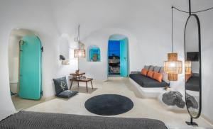 uma sala de estar com um sofá e portas azuis em Sophia Finikia Villas em Oia
