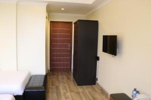 a room with a bed and a door with a television at Gigiri Express Hotel in Nairobi