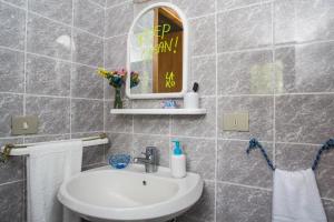 ein Bad mit einem Waschbecken und einem Spiegel in der Unterkunft Lako Hostel in Capodimonte