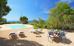 een terras met een tafel en stoelen en een zwembad bij Casa da Guarda in Alvor