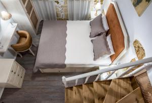 an attic room with a bed and a chair at Elvie House in Chania Town +6 photos