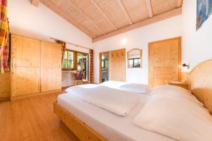 盧松的住宿－Pardellerhof Ferienhaus，一间卧室配有一张带木制橱柜的大床