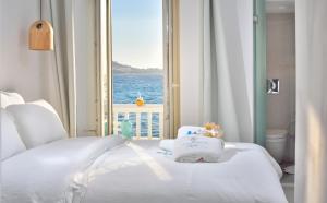 a bedroom with a bed with a view of the ocean at Little Venice Suites in Mikonos