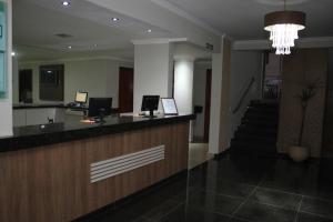a lobby with a reception desk and a staircase at Astro Palace Hotel in Uberlândia