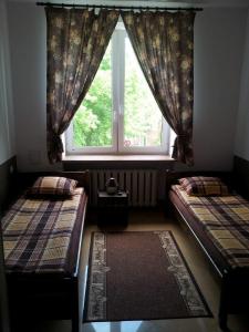 a room with two beds and a window at Hostel Maxim in Warsaw