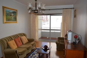 a living room with a couch and a tv at Casa da Praia de Peniche in Peniche
