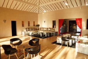 a living room with chairs and tables and a couch at La Taniere Villa Metsu in Saly Portudal