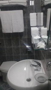 a bathroom with a sink and a toilet and towels at Hotel Perfect in Yamna