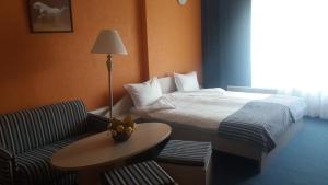 Habitación de hotel con cama, mesa y silla en Hotel Perfect en Yamna