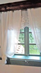 a window with white curtains in a room at Stara Iža in Selišće Sunjsko