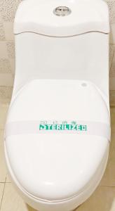 a white toilet in a bathroom with a sticker on it at Lakeside Inn in Guilin