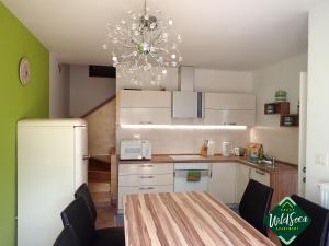 a kitchen with a table and a chandelier at Wild Soca House Apartment No.5 in Bovec
